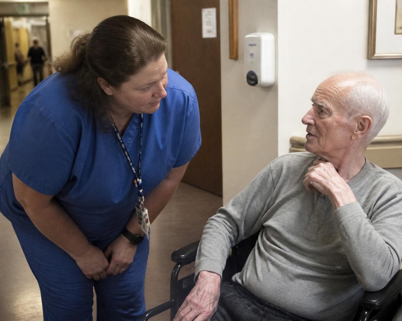 A nurse holding the hand of an elderly resident in a Maryland care facility